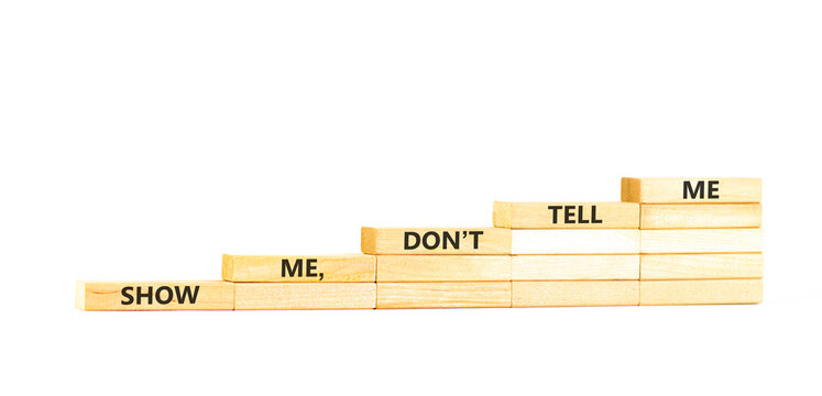Tell or show symbol. Concept words Show me, do not tell me on beautiful wooden blocks. Beautiful white paper background. Business tell or show concept. Copy space.