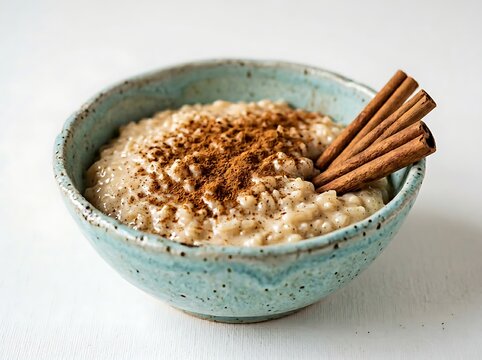 A bowl of oatmeal with cinnamon sticks and cinnamon powder on top  a delicious and healthy breakfast option