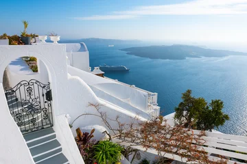 White architecture in Santorini island, Greece. Beautiful terrace with flowers. Sea view at sunny day. © smallredgirl
