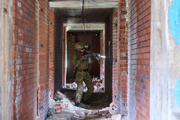 Obraz premium Tactical Soldier With Rifle Clearing A Rubble-Filled Urban Corridor During Training Operation
