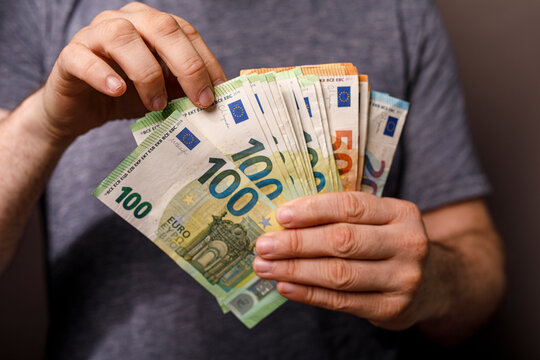 Close-up of a person's hands holding Euro banknotes, symbolizing wealth, finance, and fin