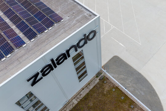 Aerial view of a modern warehouse building with solar panels and Zalando lettering on the side