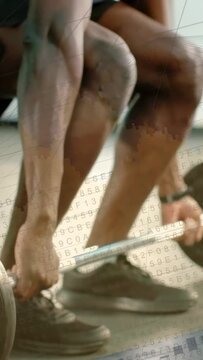 Vertical video: Two men gripping barbell, pulling up while charts overlaying to track fitness