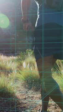 Vertical video: Runner entering, running on trail uphill, activating fitness data from watch