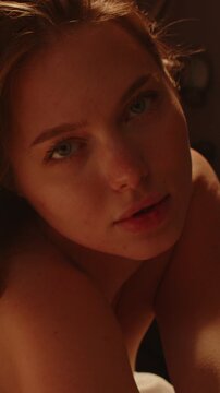 Beautiful vertical close up of an attractive woman alluringly looking at the camera in slow motion
