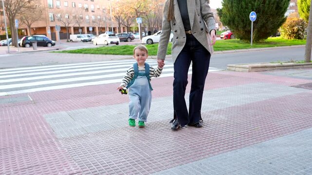Mother taking her son to daycare walking hand in hand