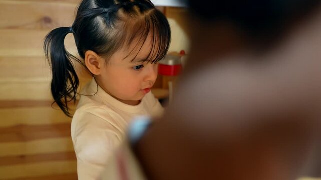 Adorable little girl pretending to cook in a play kitchen at daycare