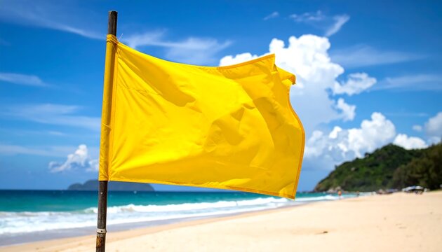 Yellow warning flag blowing in the wind on a sunny beach, clear skies