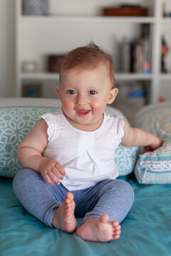 Adorable happy baby girl with big blue eyes smiling at the camera. Portrait of a joyful child, childhood, health, and happy family life.