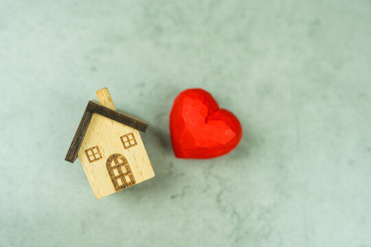 Wooden house with red heart, house of marriage relationship, holiday season greeting, vacation. Love home symbol, insurance concept