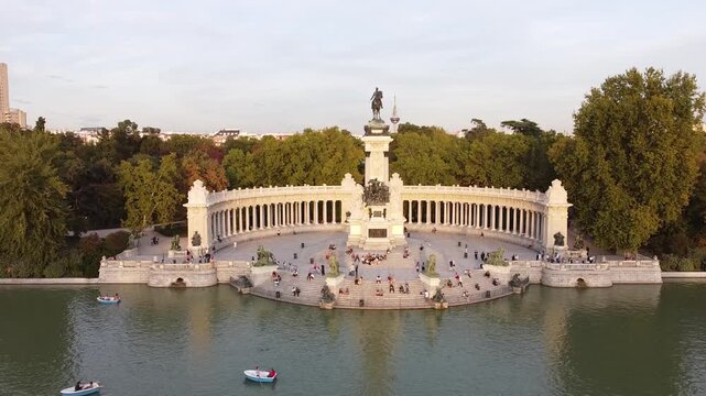 Aerial view of tourists on boats enjoying an autumn day on a great pond in front of monument to Alfonso XII at the Retiro Park (Parque del Buen Retiro) in Madrid, Spain.