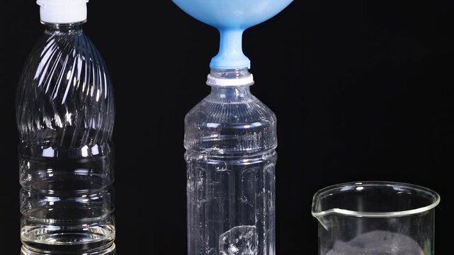 Performing a chemical reaction experiment with baking soda and vinegar to inflate a balloon, demonstrating gas production.