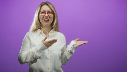 Woman wearing red glasses holds palms up and gestures questioning with open hands in studio  confusion. © Krakenimages.com