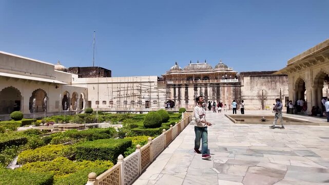 A formal garden with neatly trimmed hedges and colorful plants inside a historical complex.