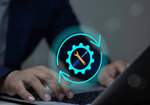System maintenance and software upgrade concept. Businessman using laptop to install updates for secure and reliable operation.