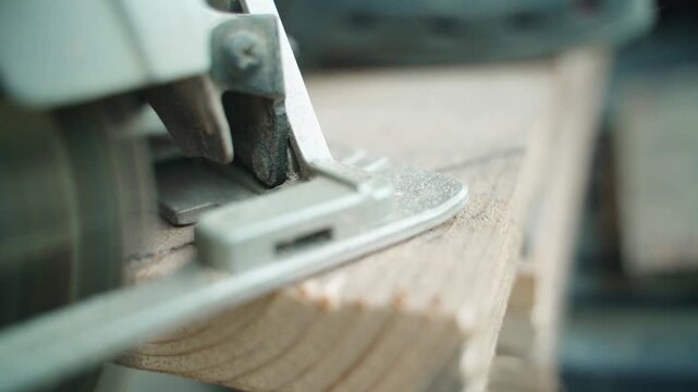 Close-up of cutting pine board with circular saw in slow motion