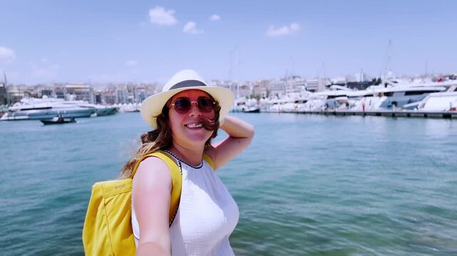 Happy vlogger girl taking selfie in piraeus port, athens