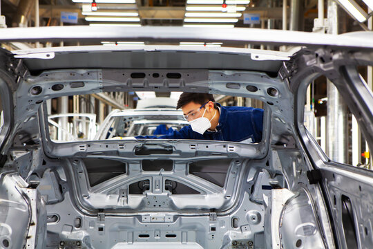  workers manufacture cars on an assembly line.