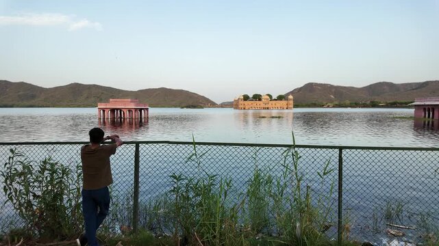 A man gazes at the Jal Mahal palace from across Man Sagar Lake.