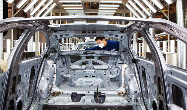  workers manufacture cars on an assembly line.