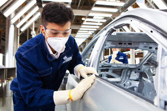  workers manufacture cars on an assembly line.