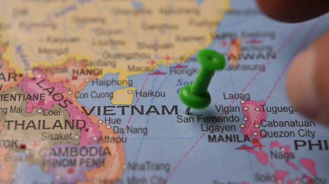 Man Pointing Green Pin on Vietnam Location Paper World Map 4K 60fps Stock Footage