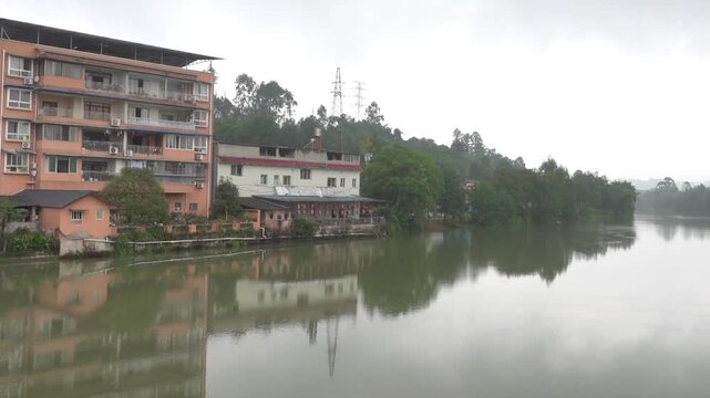 The legacy of the tradition of pile settlements. Apartment buildings on stilts right near the water's edge on the river. China. Xining