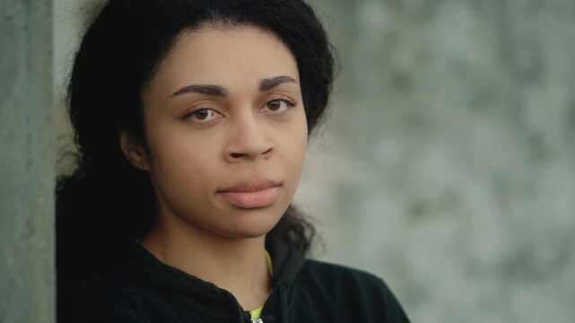 Portrait of young African American woman feeling lonely and upset outdoors