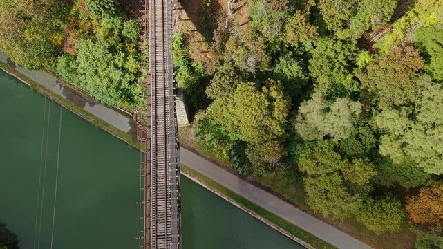 Lockport, New York, USA. Historic Upside Down Railroad Bridge over Erie Canal with rail tracks above green canal water 