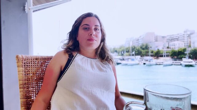 Young woman vlogging and relaxing at a seaside cafe in piraeus, athens