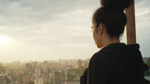 Upset African American woman looking down from rooftop, afraid of heights