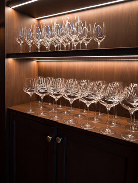 Elegant Wine Glass Display on Wooden Shelves with Warm Lighting