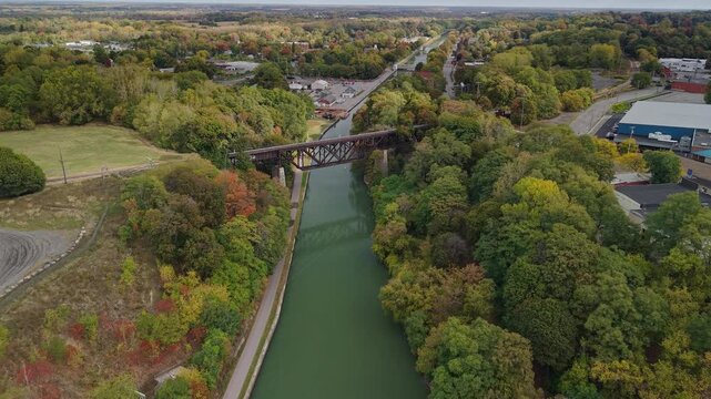 Lockport, New York, USA. Historic Upside Down Railroad Bridge spanning the Erie Canal with colorful autumn forest and canal towpath