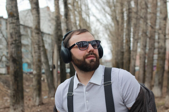 man with beard and headphones in the park