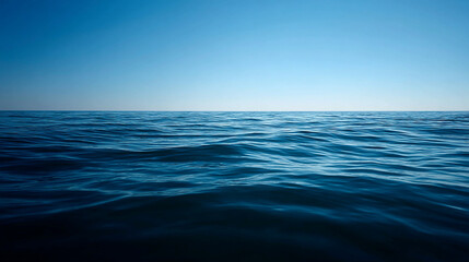 Fototapeta premium Vast deep blue ocean surface with ripples and clear sky on a bright sunny day tranquil seascape