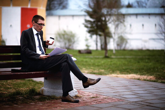 A man in a suit lies on a brick floor