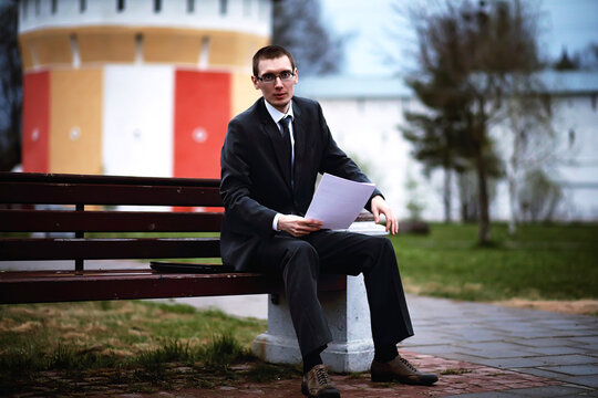 A man in a suit lies on a brick floor