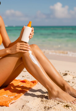 Donna che applica la crema solare sulle gambe in spiaggia estate