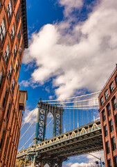 Naklejka premium Stunning view of the Manhattan Bridge amidst Brooklyn's brick buildings
