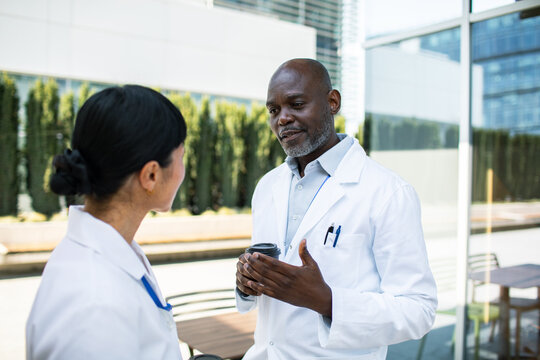 Doctors talking outside hospital during coffee break