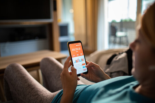 Woman tracking workout on smartphone at home