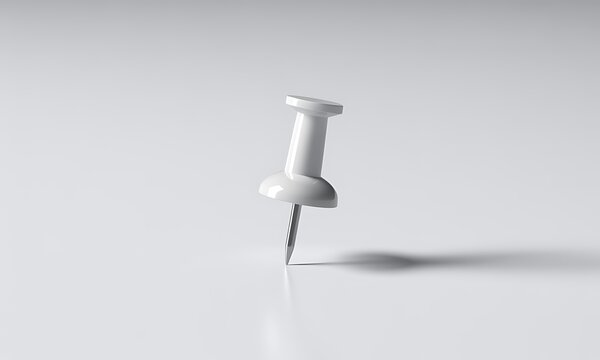 Single white push pin standing upright on a flat surface