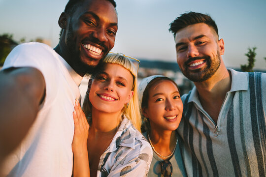 Diverse friends taking a happy selfie together outdoors