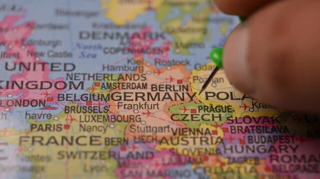 Close-Up World Map Shot Featuring Green Pin Highlighting Germany Pointed by Hand 4K 60fps
