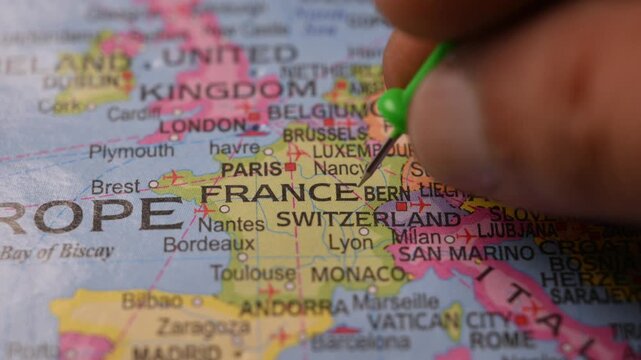 Close-Up World Map Shot Featuring Green Pin Highlighting France Pointed by Hand 4K 60fps