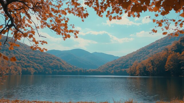 Vibrant Autumn Lake Scenery Framed by Orange Leaves and Misty Mountains Under a Blue Sky