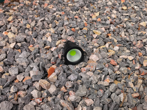 COB LED garden spotlight for landscape lighting on rocks.