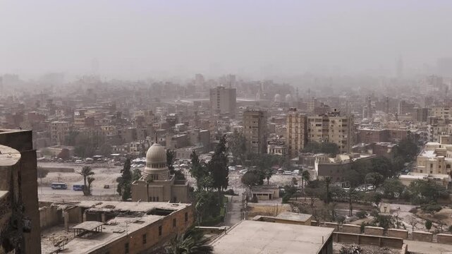 Medieval Mamluk mosques with ornate stone facades, soaring minarets and large domes against a hazy Cairo horizon, one of Egypt's most iconic religious landmarks.