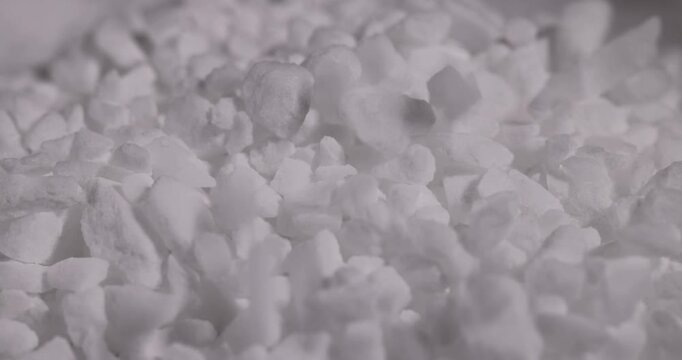white coarse solid salt that is used in dishwashers to improve and soften water, coarse crystals of special salt for dishwashers for good and long-lasting dishwasher operation