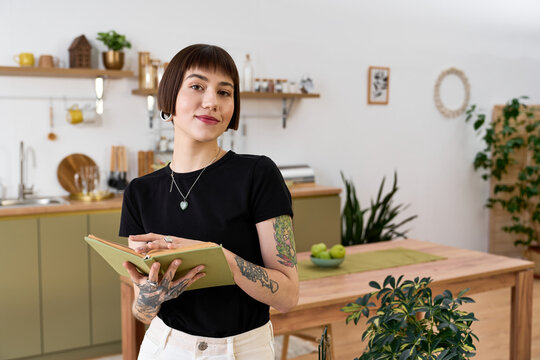 Young woman captures inspiration in her beautiful home kitchen while writing in her journal
